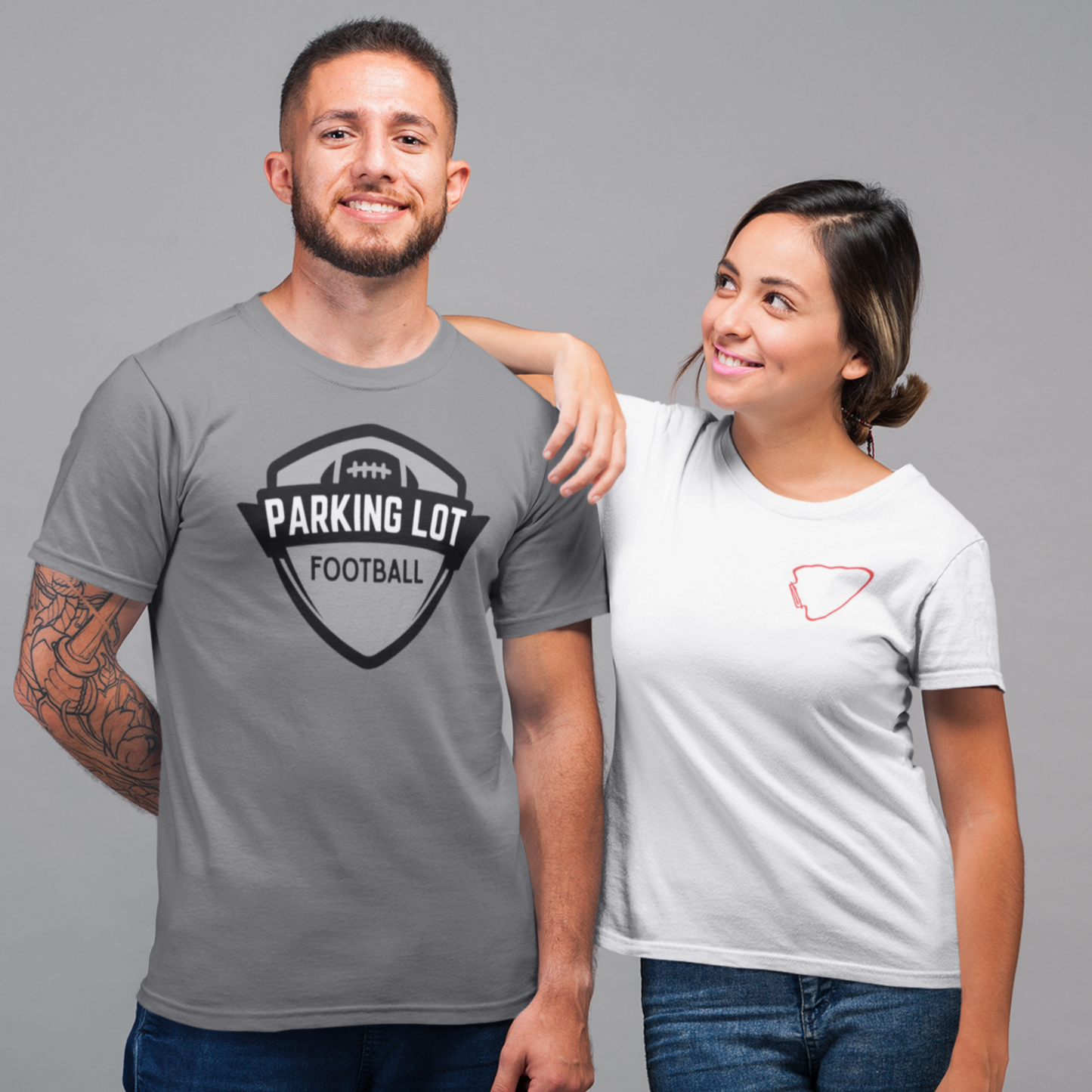 Two people wearing t-shirts with visible designs on a gray background
