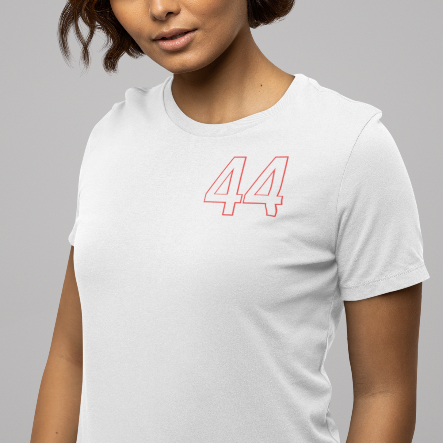 Person wearing a white t-shirt with red number 44 design on a gray background