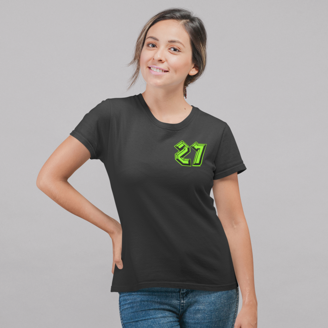 Woman wearing a black t-shirt with the number 27 in green on a gray background